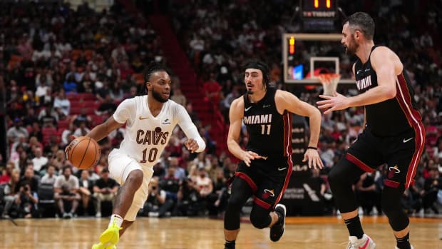 Dec 8, 2023; Miami, Florida, USA; Cleveland Cavaliers guard Darius Garland (10) drives the ball around Miami Heat guard Jaime Jaquez Jr. (11) and forward Kevin Love (42) during the second half at Kaseya Center. Mandatory Credit: Jasen Vinlove-USA TODAY Sports